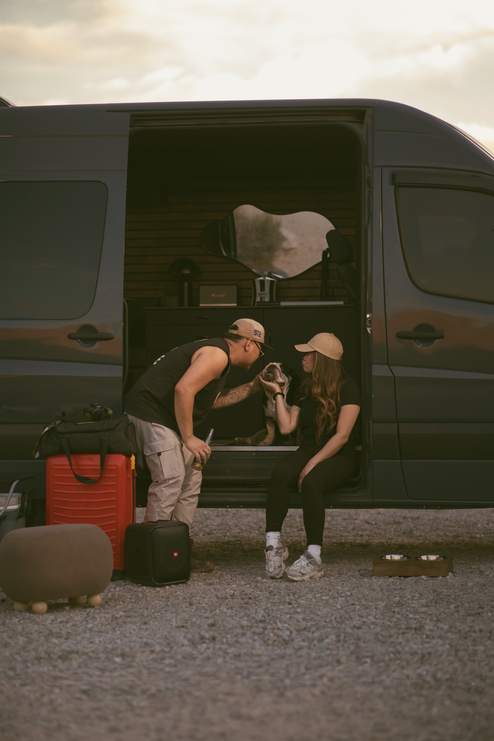 Couple and dog relax by their customized rv rental van. Inside, a cozy interior. Perfect for memorable van life adventures.