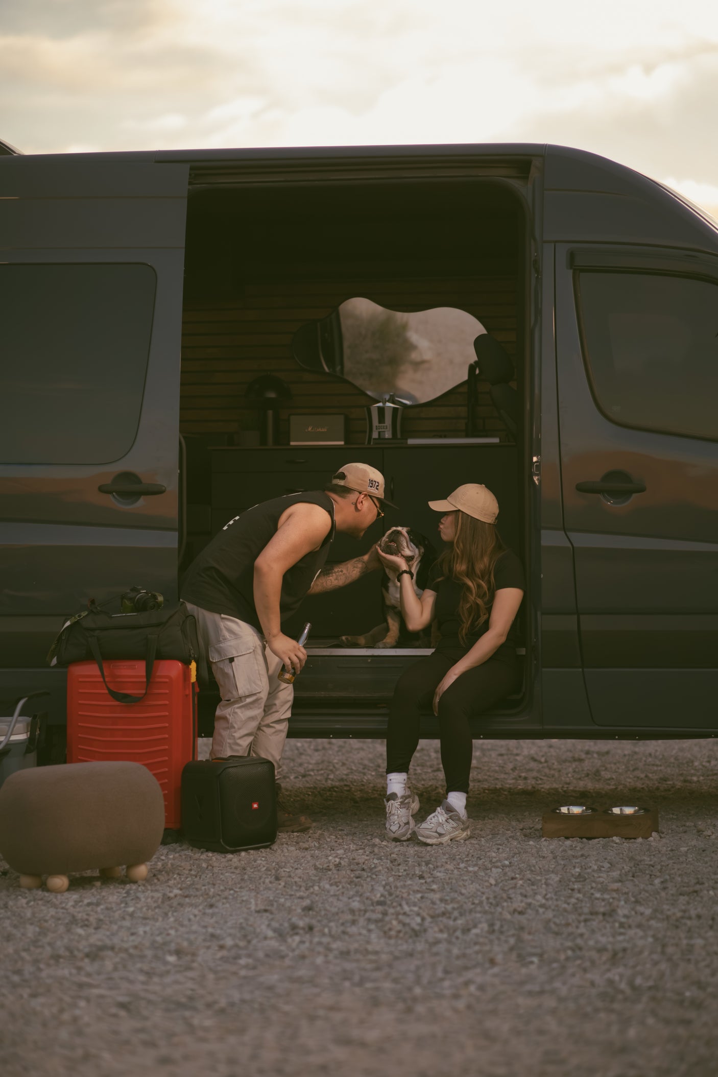 Couple and dog relax by their customized rv rental van. Inside, a cozy interior. Perfect for memorable van life adventures.