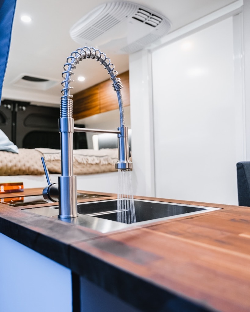 enjoying the comforts of mobile living.|Spacious RV rental interior: A woman reads in the bunk