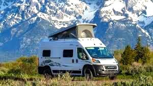 Majestic snow-capped mountains frame this white camper van RV rental
