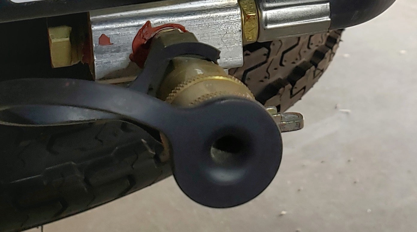 This RV rental image shows a tire with aggressive tread, and a brass valve fitting with a black protective cap on the chassis.