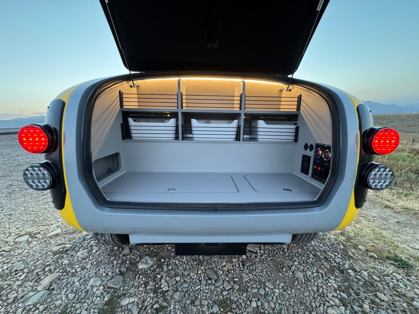 Explore this RV rental's functional rear storage, featuring lights, power, & organized bins, perfect for your next trip.
