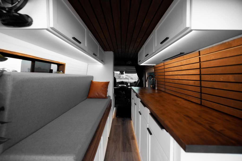 and ample storage for mobile living.|This modern rv rental interior features a comfy bed