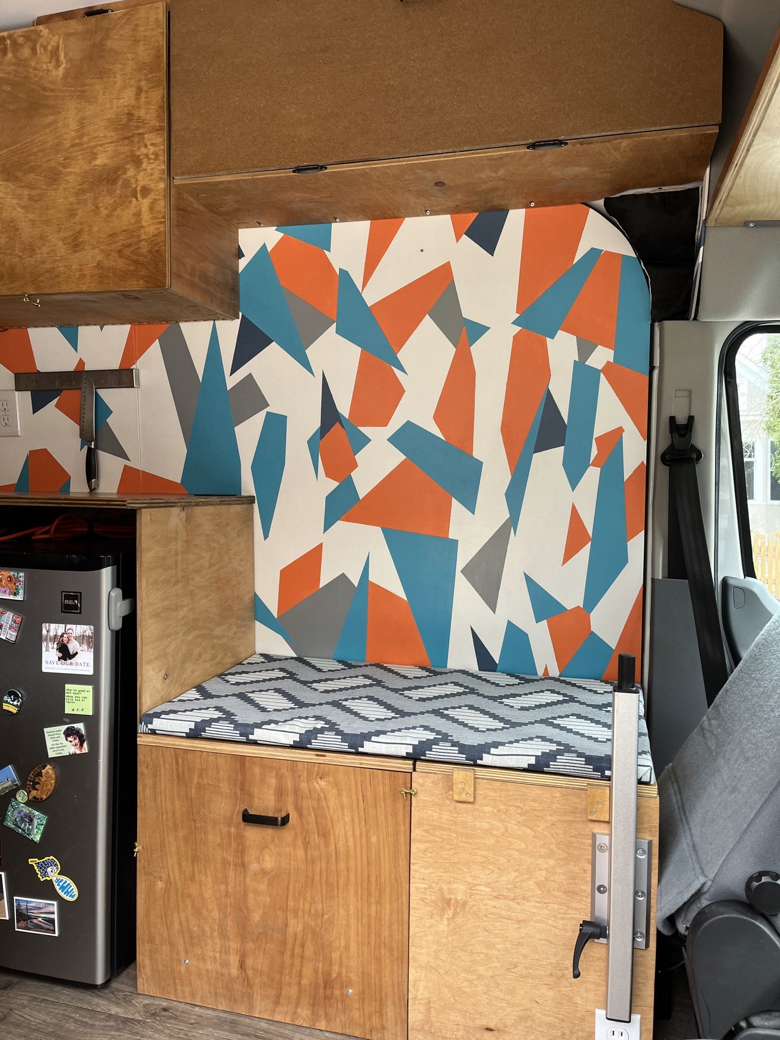 and overhead cabinets.|This RV rental offers a well-equipped camper van interior featuring a kitchen with stove/sink