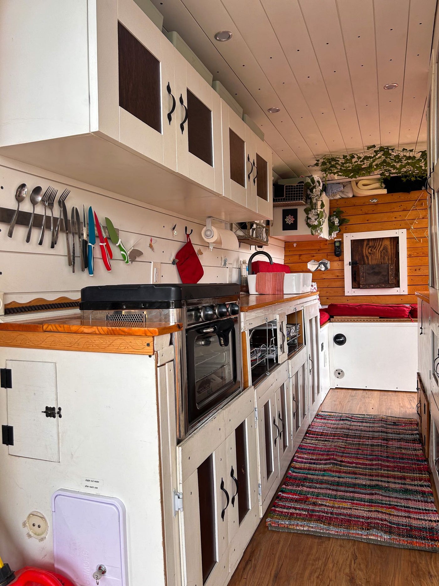 and smart storage for road trips.|Compact RV rental kitchen with white cabinetry — photo 2
