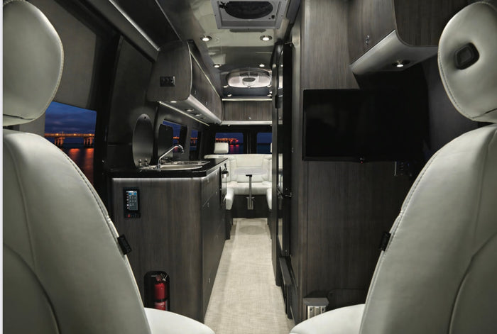 sleeps 2.|Experience van life! This RV rental offers peaceful nature retreats. Silver camper van in a grassy field