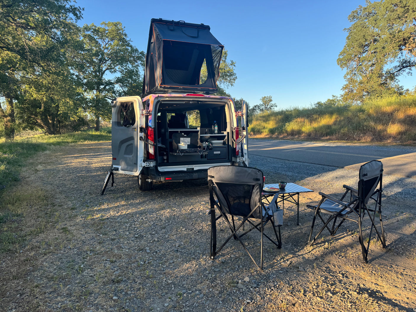 Enjoying the outdoor kitchen of our RV rental campervan with a pop-top tent. Perfect for a scenic road trip!