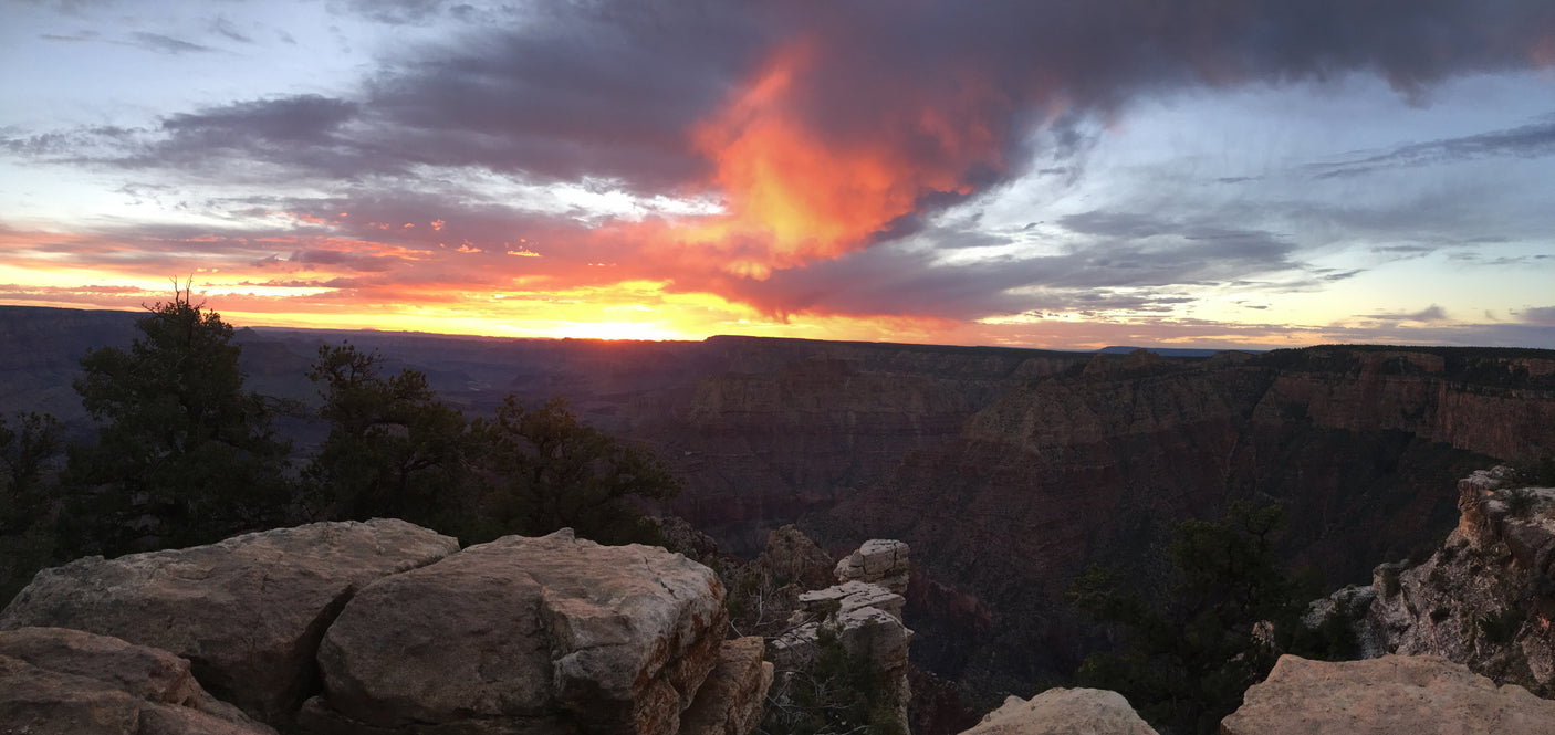 Panoramic Grand Canyon sunset. Fiery clouds illuminate vast layered rock formations. An incredible view for your RV rental adventure.
