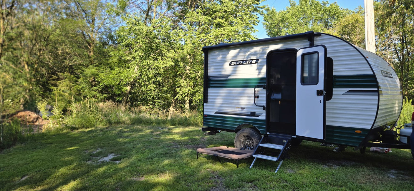 perfect for outdoor adventures in a wooded setting.|RV rental camping setup: Sun Lite travel trailer