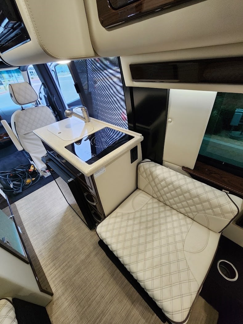 & cup holders. RVs line the lot outside.|Explore this comfortable RV rental interior: a sleek kitchen