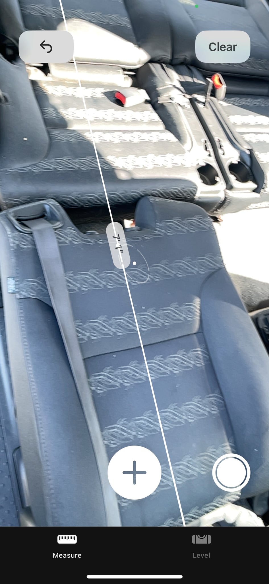 is parked in a suburban driveway. Ideal for an rv rental getaway.|Measuring the 5' 7" interior space of an RV rental using a phone app — photo 11