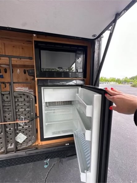 beside a gray Mercedes Sprinter van.|A white teardrop RV rental camper with an open outdoor kitchen is parked on a driveway. Ready for adventures.|This white Classic Sunray teardrop RV rental with blue accents