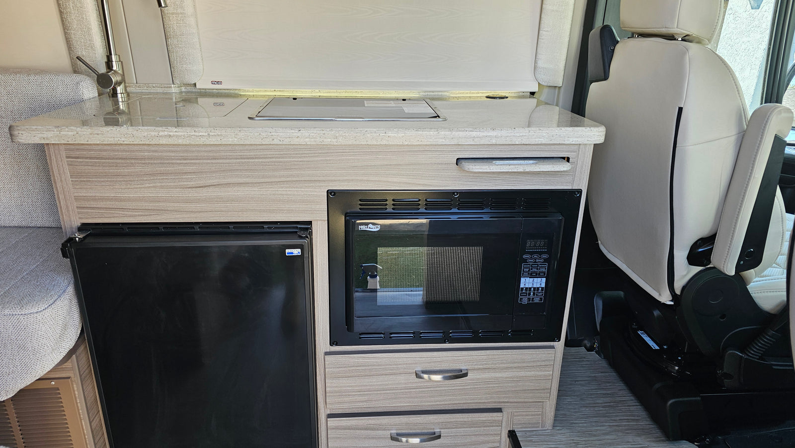 and bench seating.|RV rental: Rear view of a compact camper van's interior