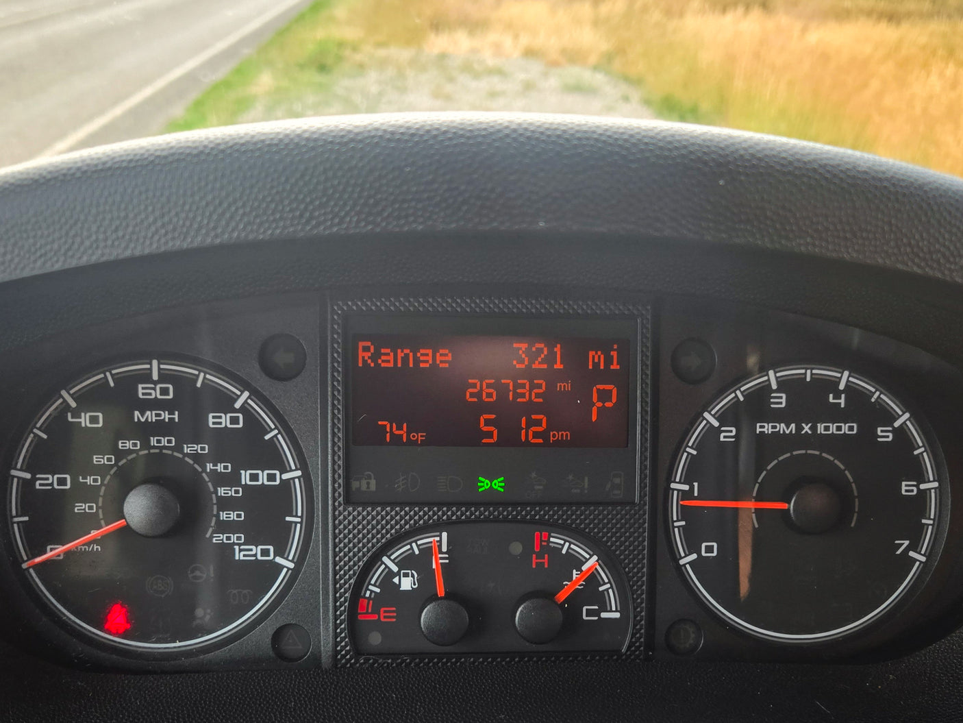 Inside an RV rental: Dashboard shows 0 mph, 74°F, 5:12 pm, full tank, 26,732 mi. In Park, ready for adventure.