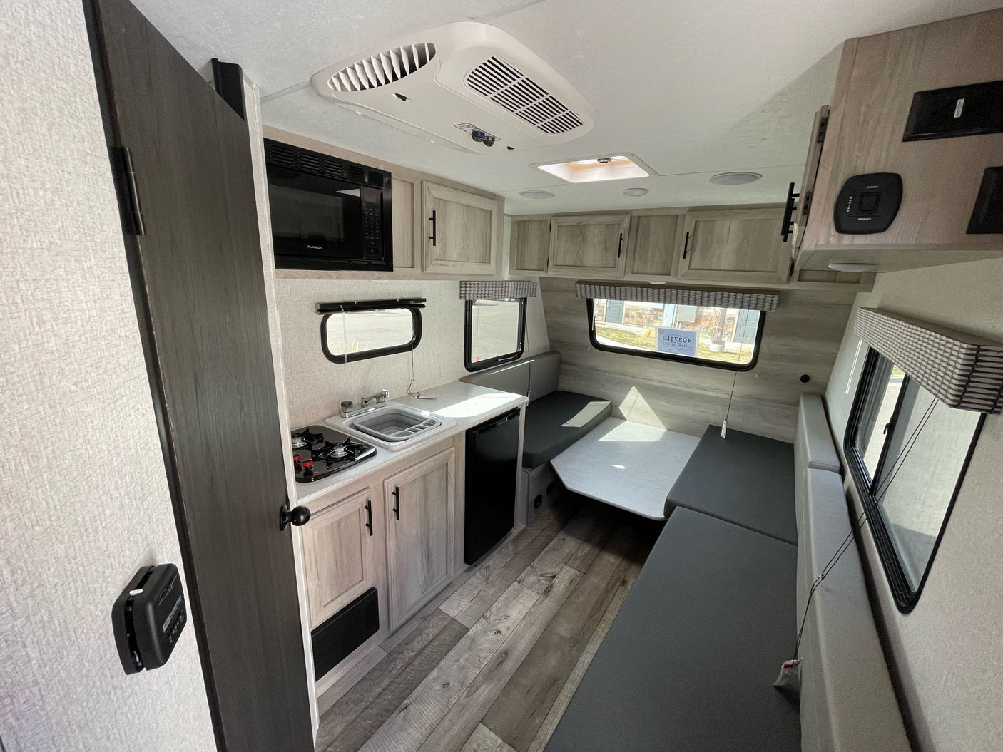 with other campers and autumn trees under a blue sky.|Sportsmen Classic RV rental floor plan. View shower