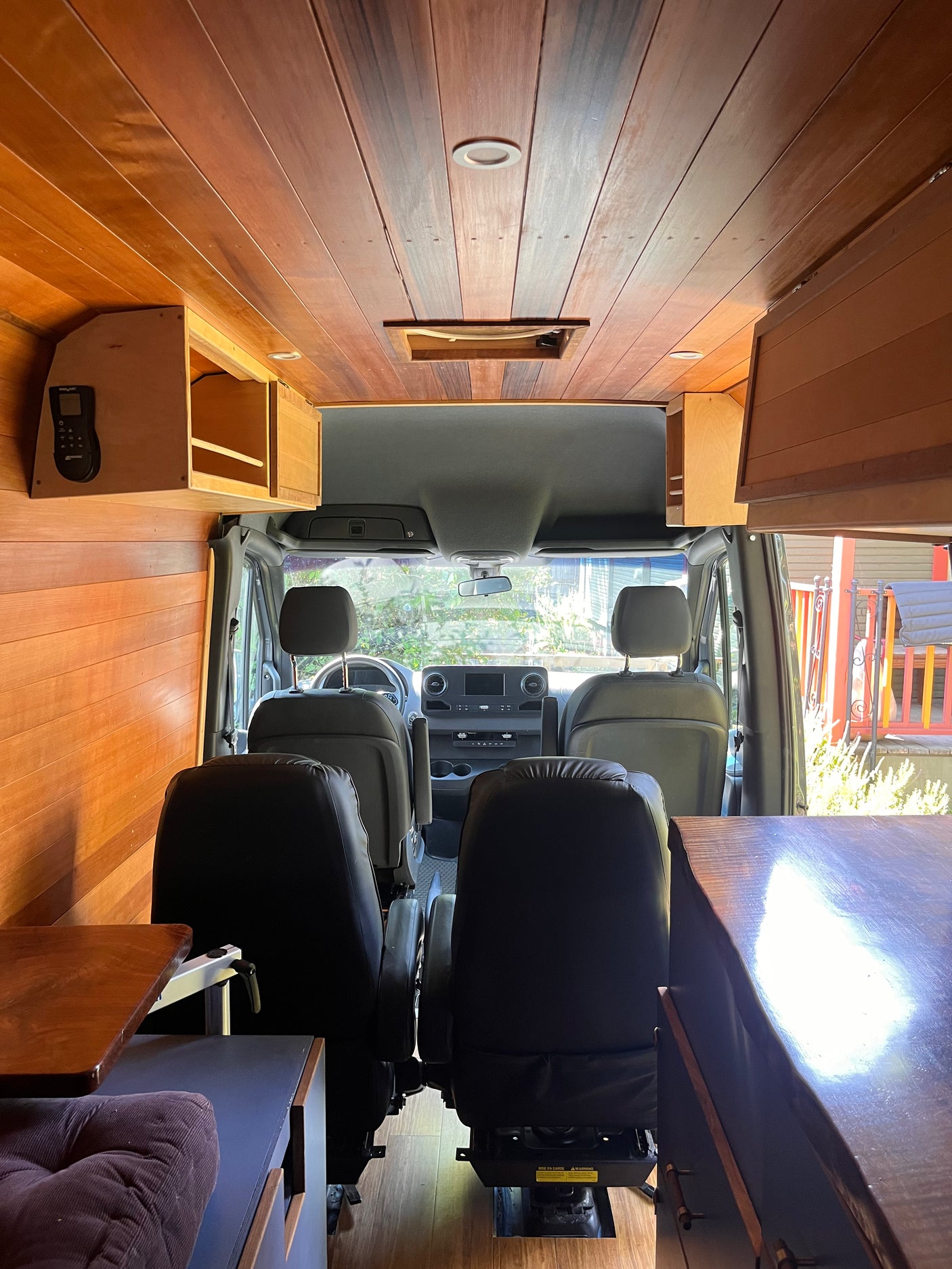 Spacious RV rental interior with warm wood finishes, custom cabinetry, and the vehicle's front cockpit visible.