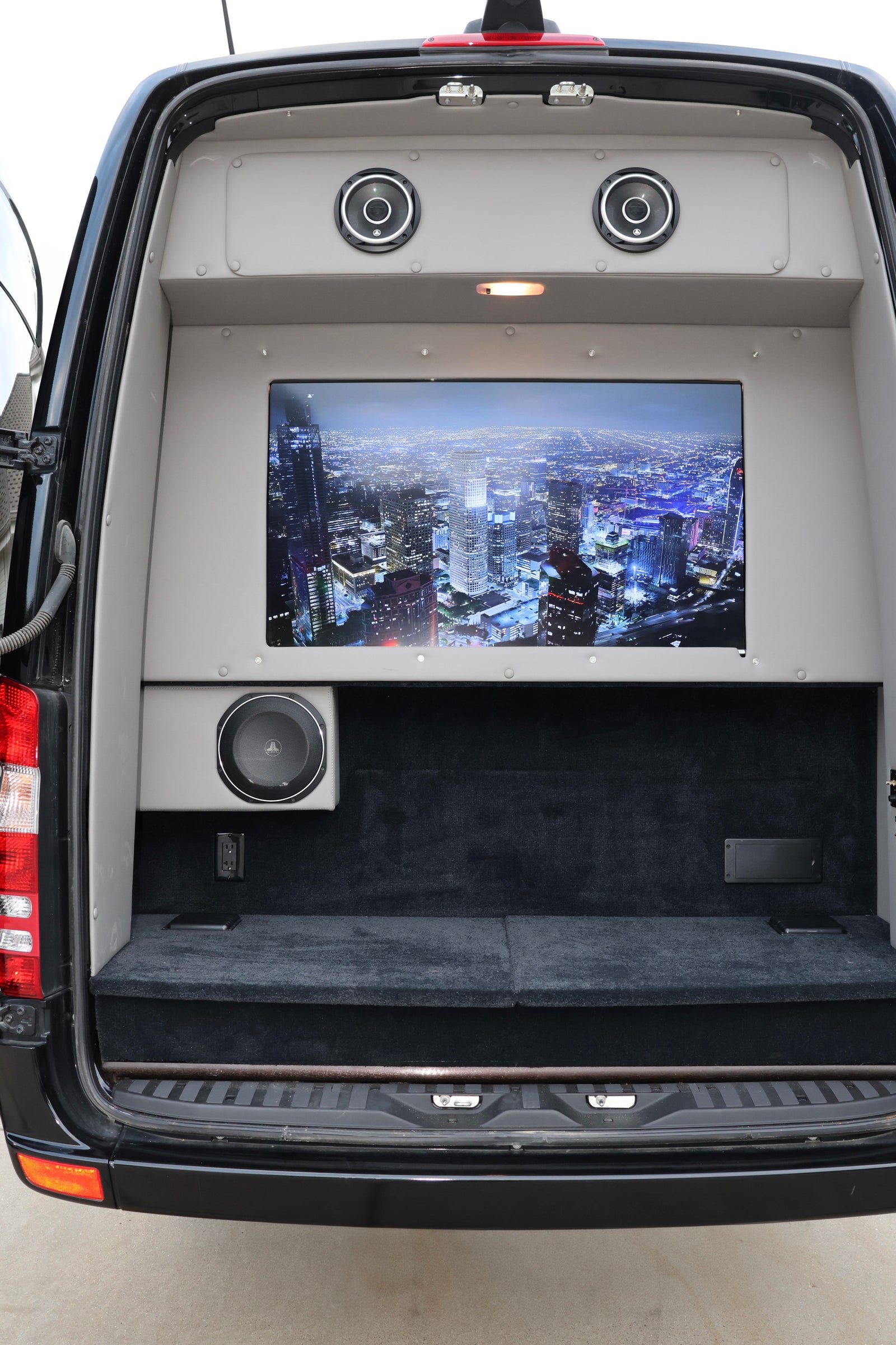 Inside this RV rental's custom rear: a large screen TV, dual JL Audio speakers, and a powerful subwoofer for entertainment.