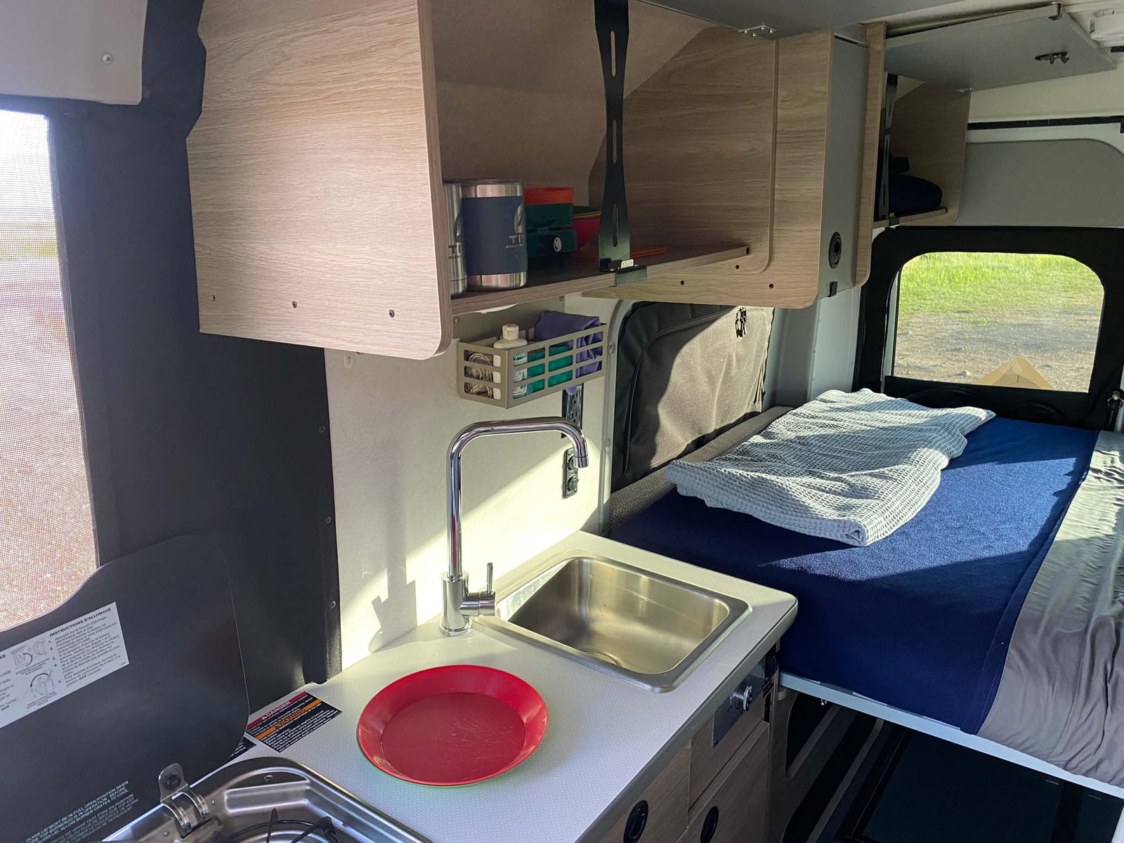 bathed in golden light under cloudy skies.|Inside an RV rental: compact kitchen with sink