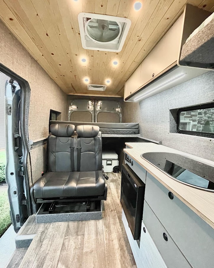 enjoying a beautiful mountain view.|Inside a modern RV rental: light wood ceiling