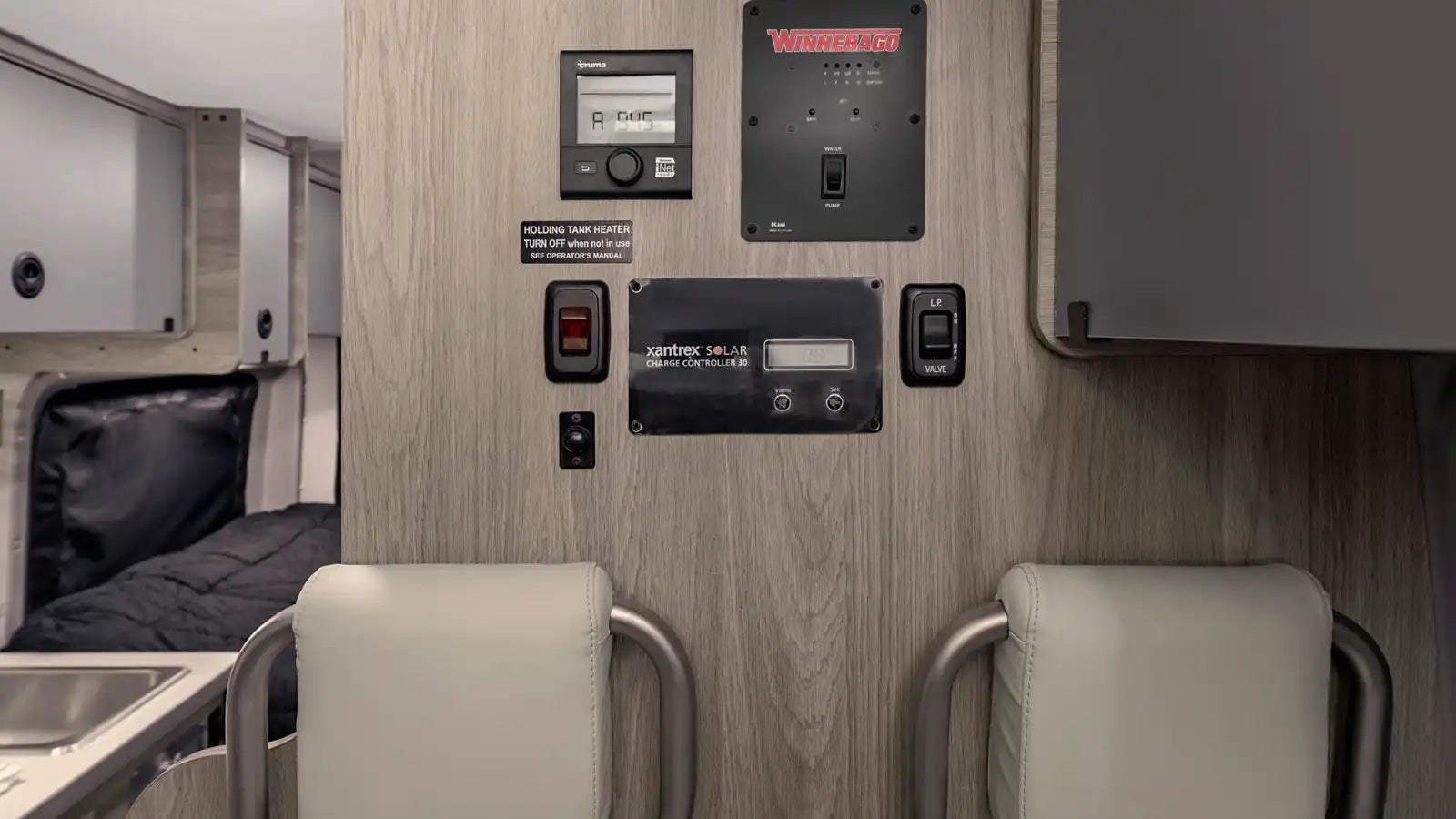 RV rental: Detailed view of the RV's control panel wall, featuring solar, water, heat, and LP gas systems.