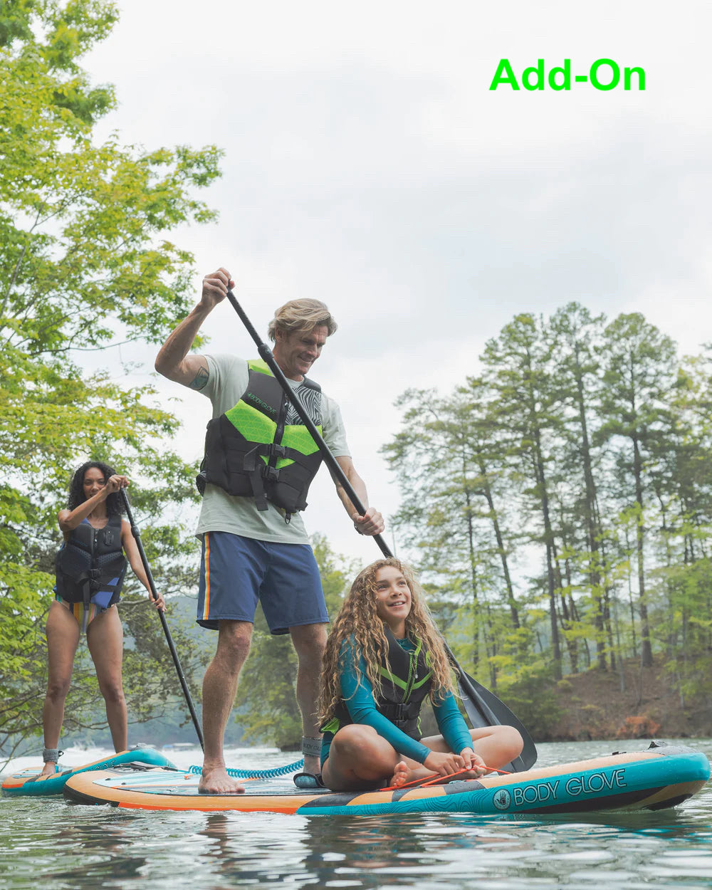 Three people, two adults and a child, enjoy paddleboarding on a lake. Perfect outdoor recreation for your RV rental getaway!