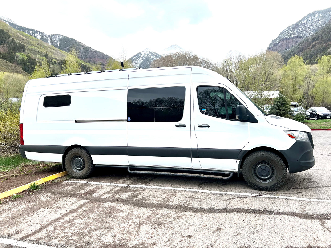 White Sprinter RV rental van in a mountain setting, ideal for adventure & road trips.