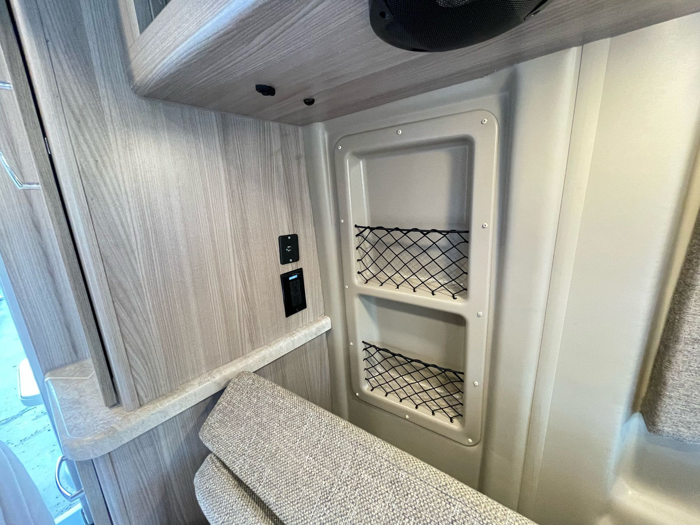 RV rental interior: functional storage with mesh pockets, USB charging, and comfortable seating in a compact space.