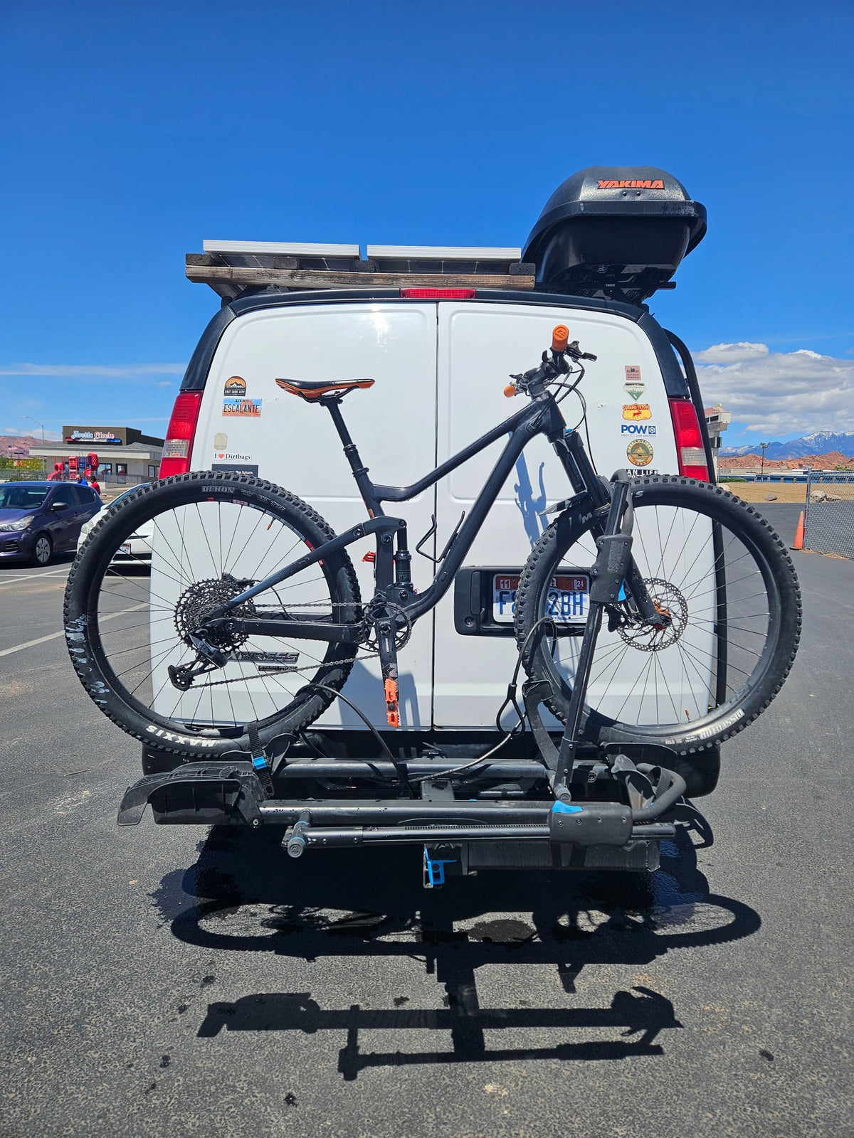 surrounded by rocks.|White RV rental van with a roof cargo box and bike rack — photo 10