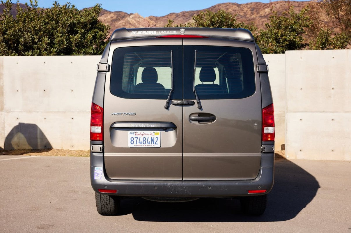 Rear view of a tan PeaceVans Modern Mercedes-Benz Metris camper van, an excellent option for rv rental adventures.