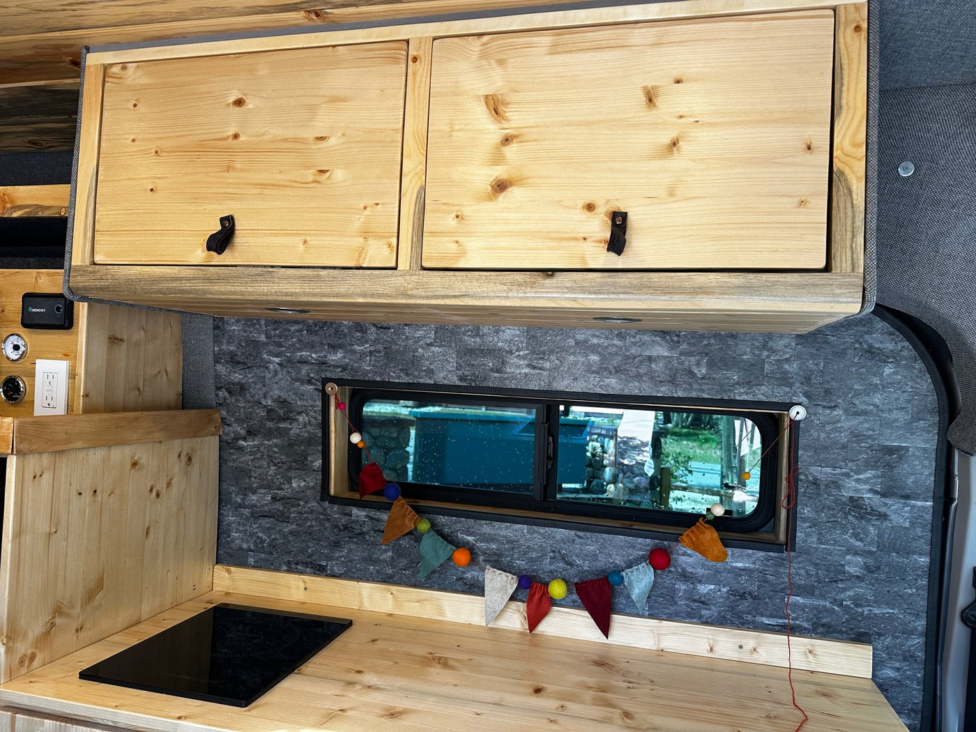 and functional storage below.|Spacious RV rental camper van with custom wood interior and ample storage — photo 9
