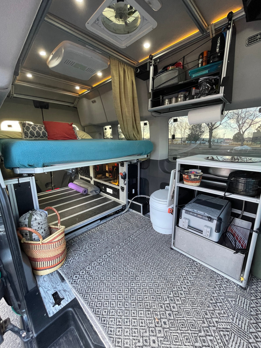 Experience van life in this RV rental! Elevated bed, compact kitchen, toilet, and smart storage fill this cozy camper van.