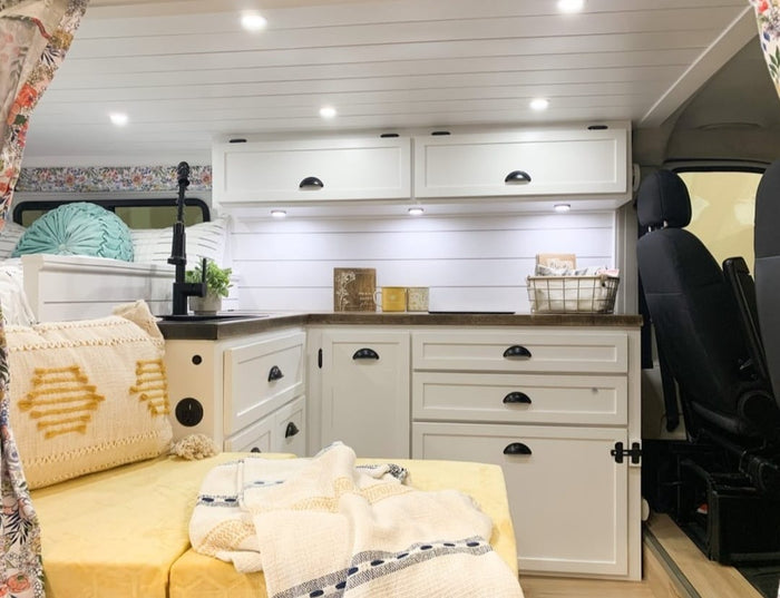 and vibrant floral accents.|Cozy RV rental interior featuring a compact kitchenette with a sink