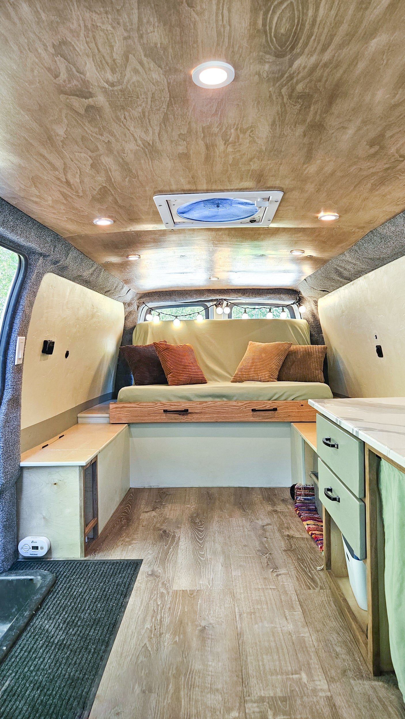 Cozy RV rental interior featuring a wood ceiling, recessed lights, comfy sofa, and practical built-in storage.