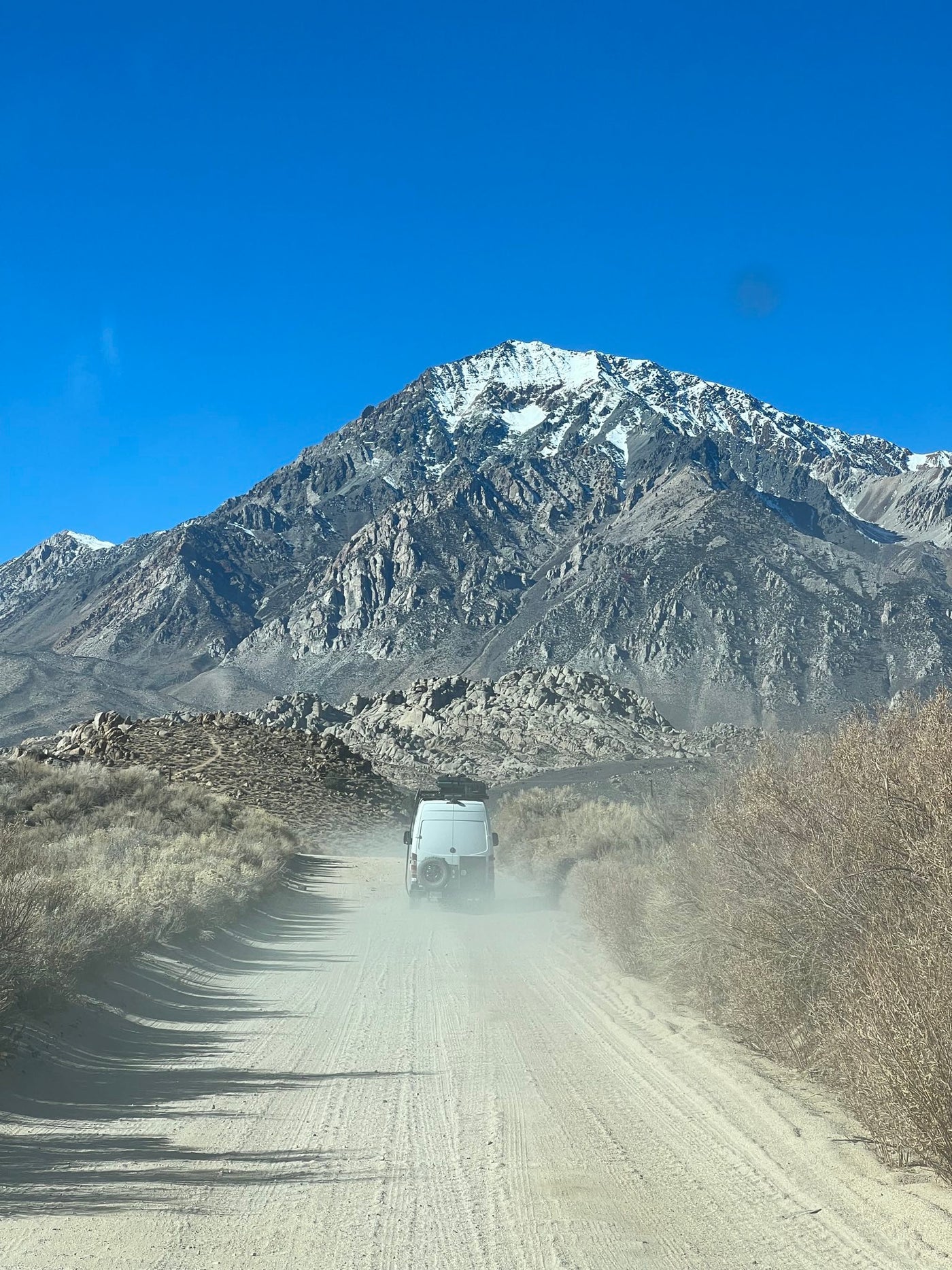 on a sunlit forest road with atmospheric light rays through trees.|Nighttime desert scene: An RV rental parked — photo 5