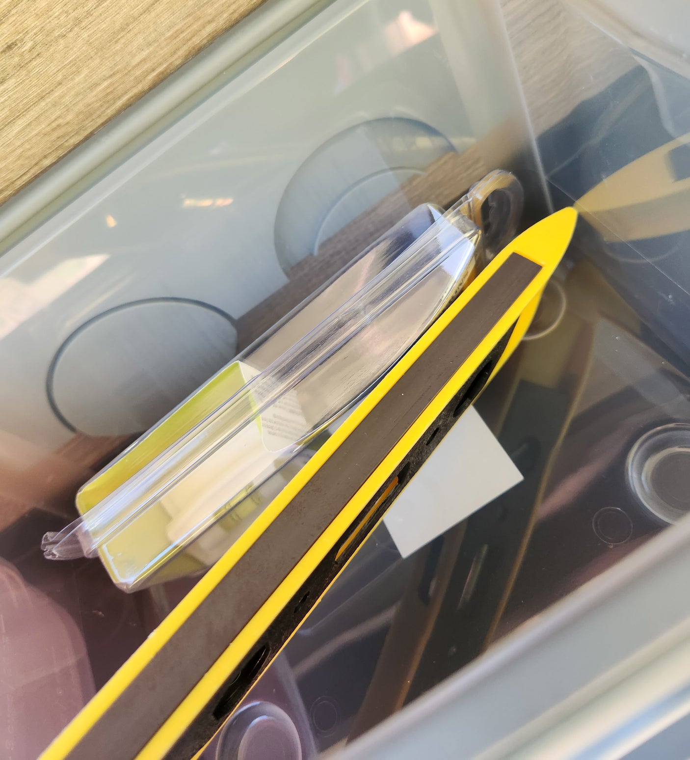 RV rental essentials: A yellow leveling block and other camping gear neatly stored in a clear bin.
