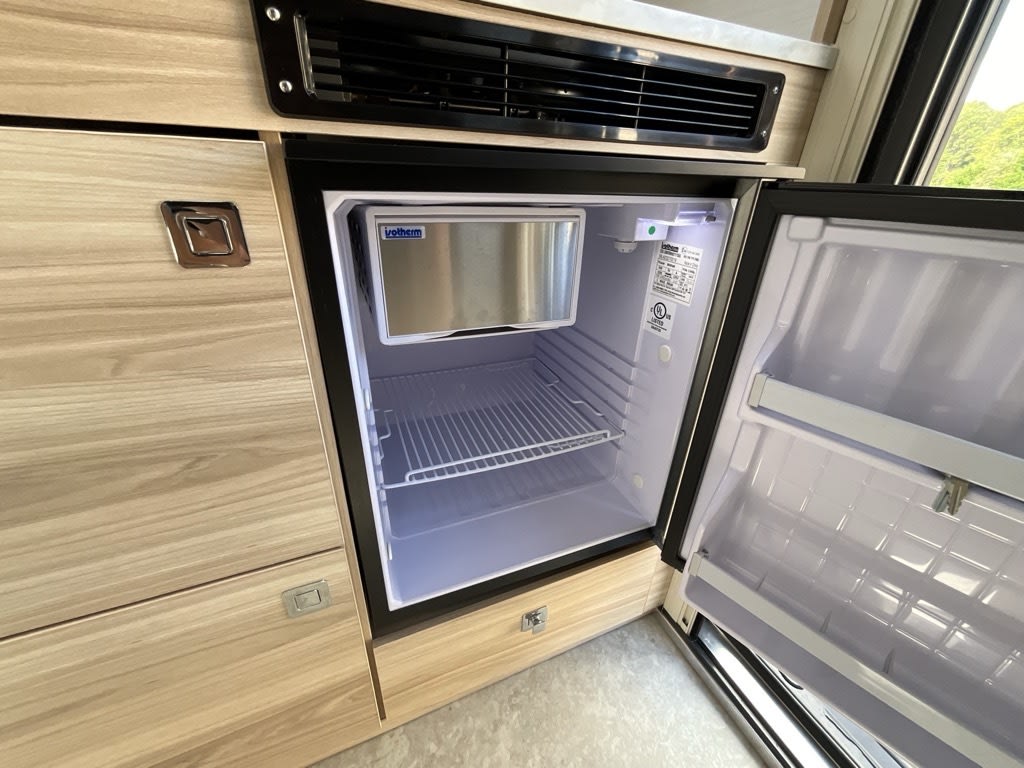 and marble-look counters for your adventures.|Enjoy a beautiful rv rental camping experience! A teardrop camper and SUV are parked by a sandy beach