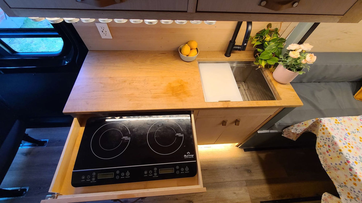 securely strapped down on a slatted wooden floor.|Cozy RV rental interior featuring a full kitchen — photo 12