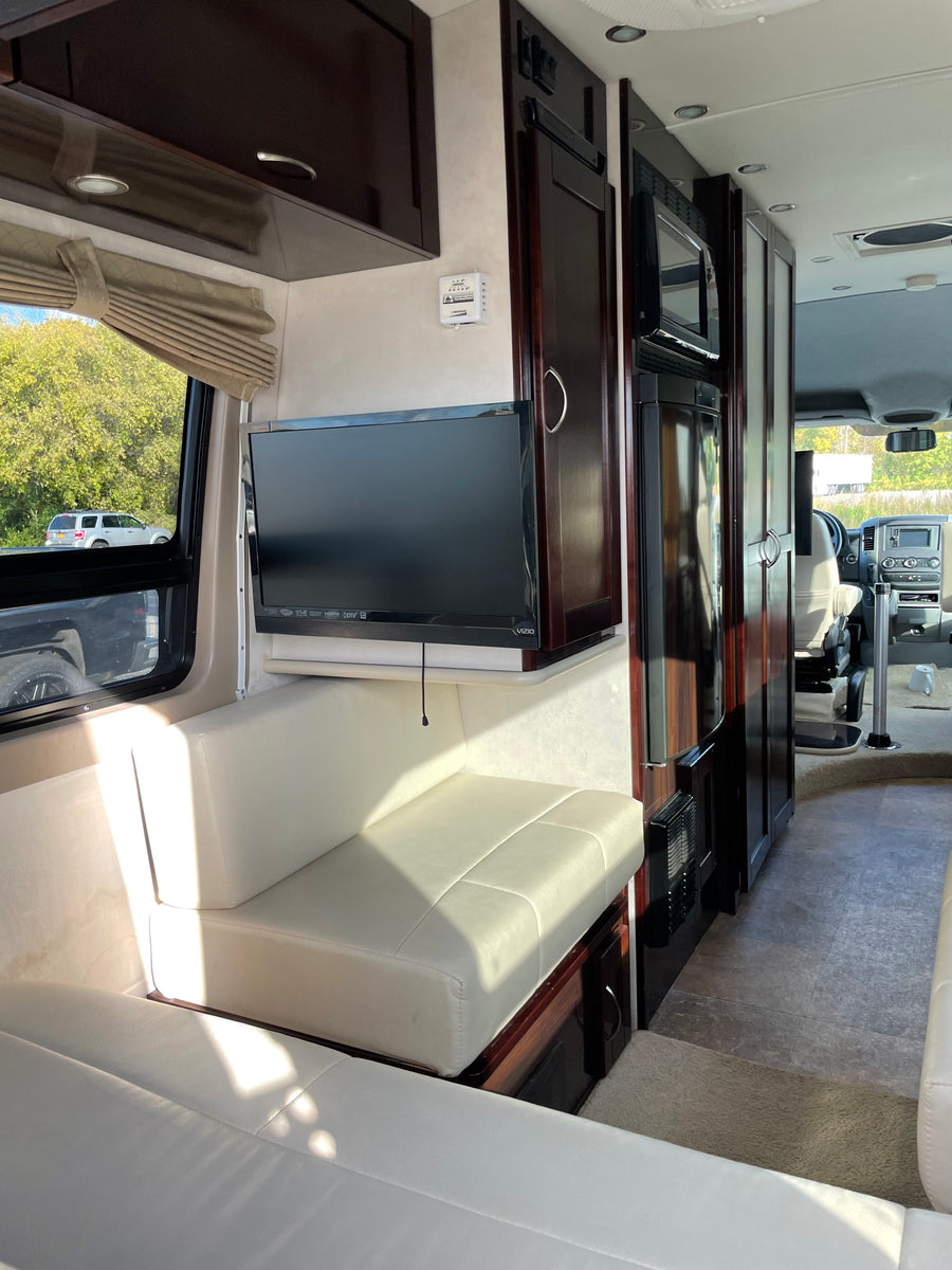 microwave & fridge. Ideal for road trips.|Compact RV rental kitchen features dark wood cabinets