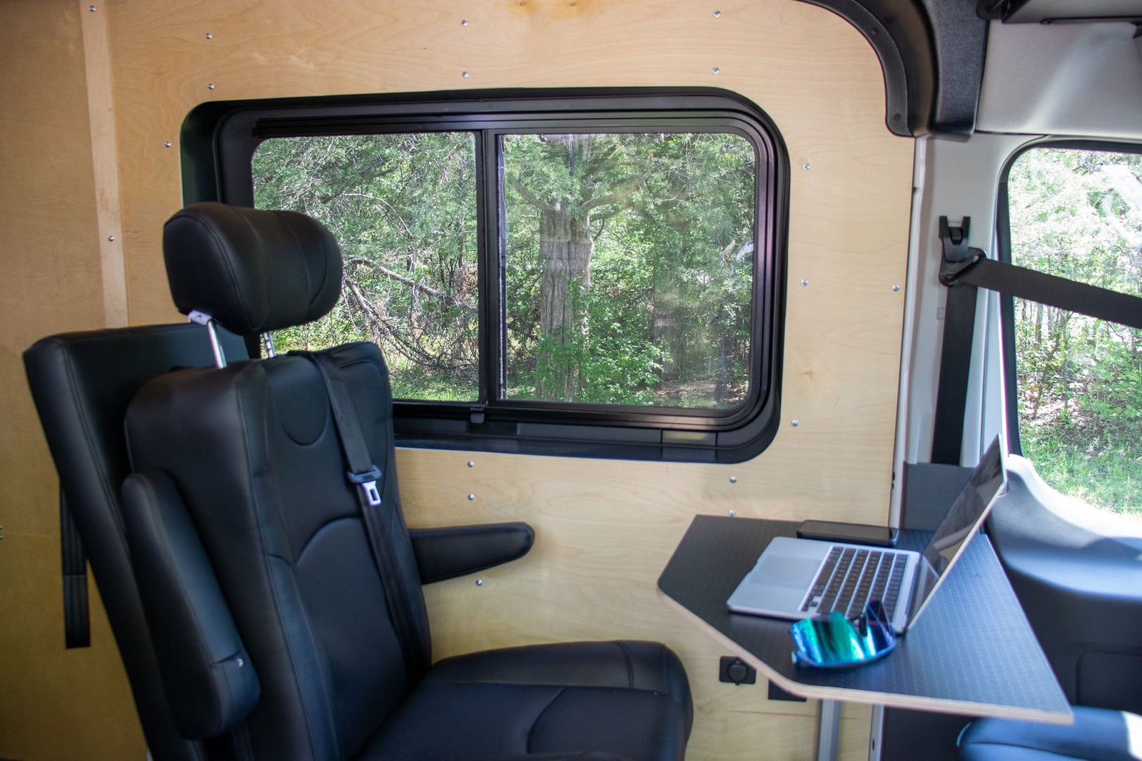 This RV rental offers a comfortable mobile office setup with a window view of nature. Perfect for remote work while traveling!
