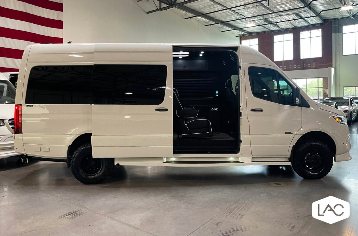 White luxury Sprinter van, side door open to reveal spacious custom interior. Ideal for rv rental adventures.