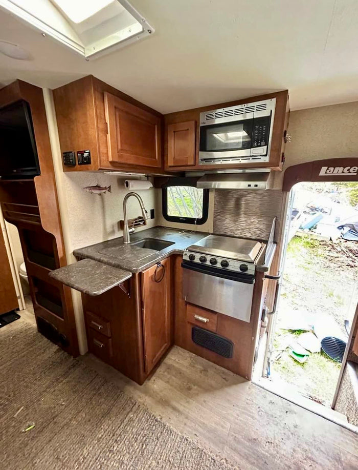 and a cozy bed. Experience comfortable travel.|RV rental interior: A cozy dinette with a fold-down bunk bed above