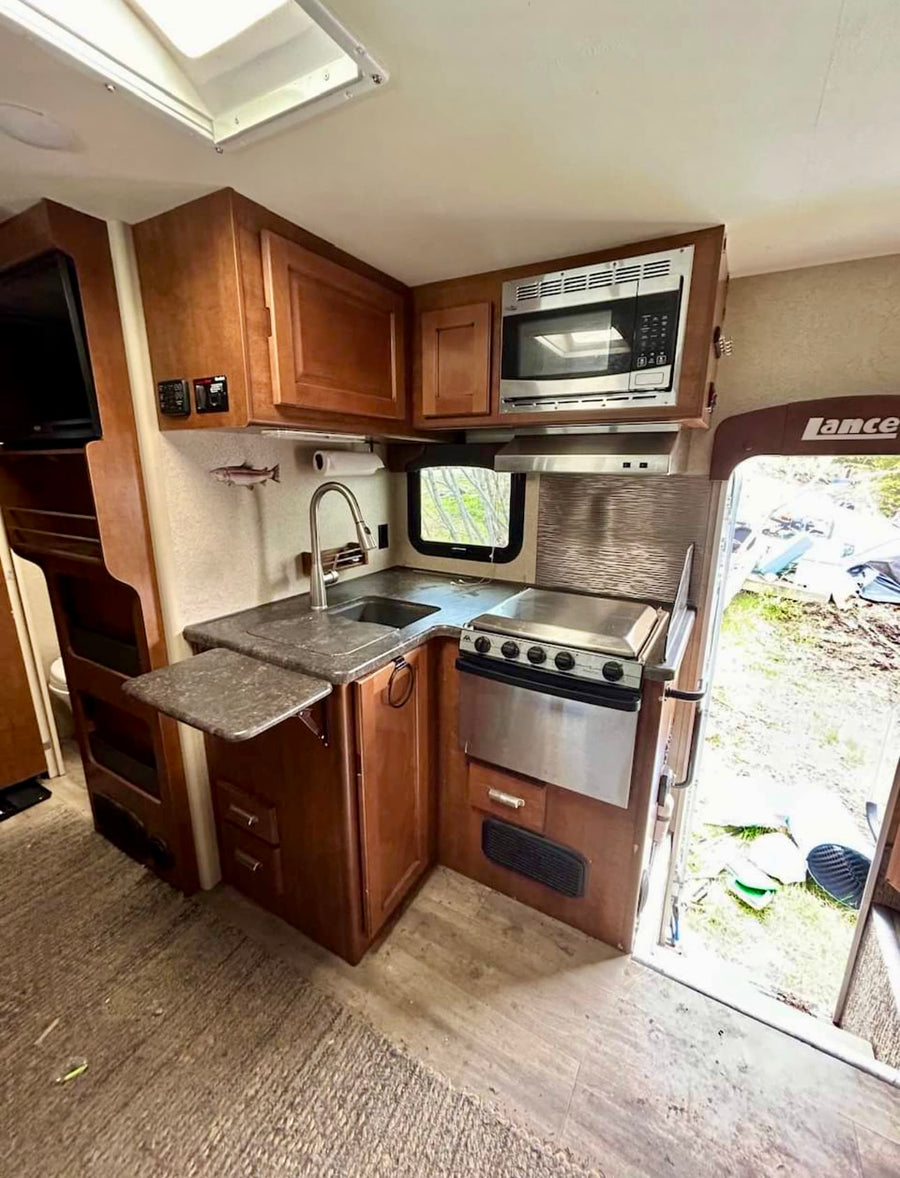 and a cozy bed. Experience comfortable travel.|RV rental interior: A cozy dinette with a fold-down bunk bed above