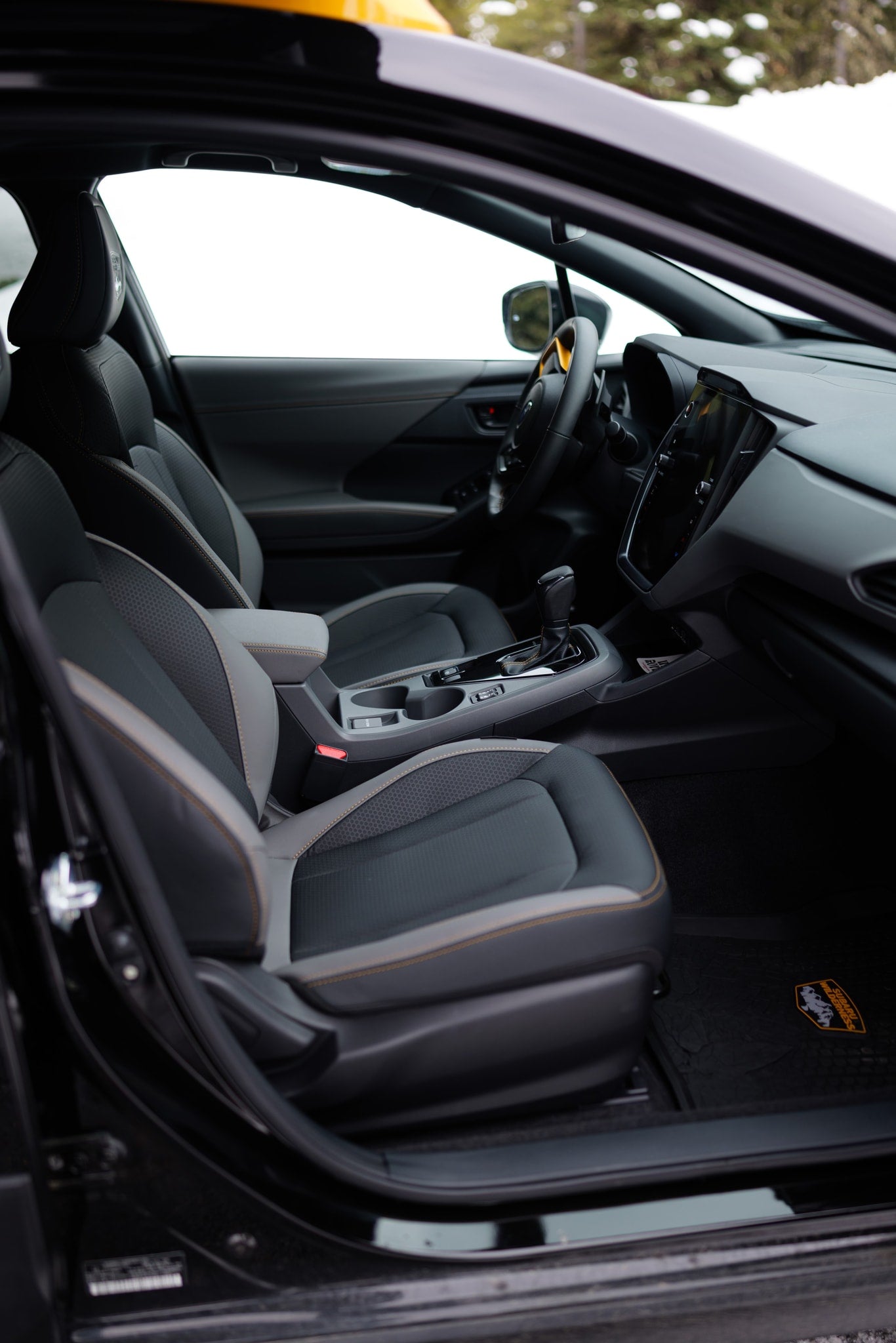 Modern vehicle interior: two-tone seats, tech display, and shifter. Ready for snowy roads and your RV rental adventure.