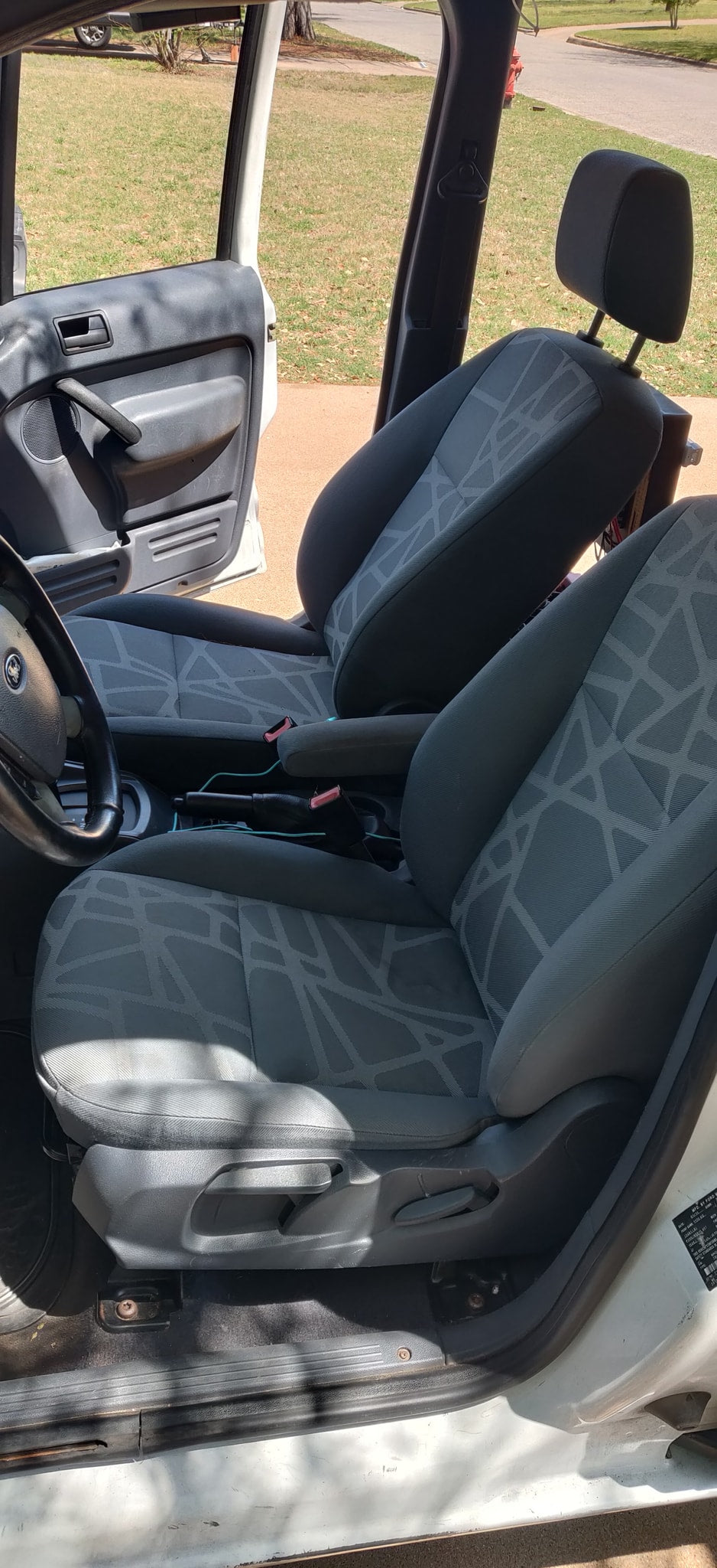 Interior of an RV rental van: driver and passenger seats with patterned fabric, open door, and steering wheel visible. — photo 20