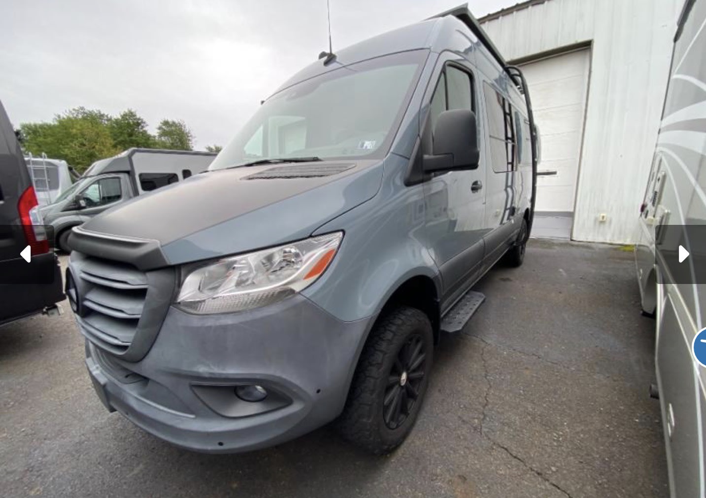 Stylish gray Mercedes Sprinter RV rental camper van with rugged tires and a protective front bumper