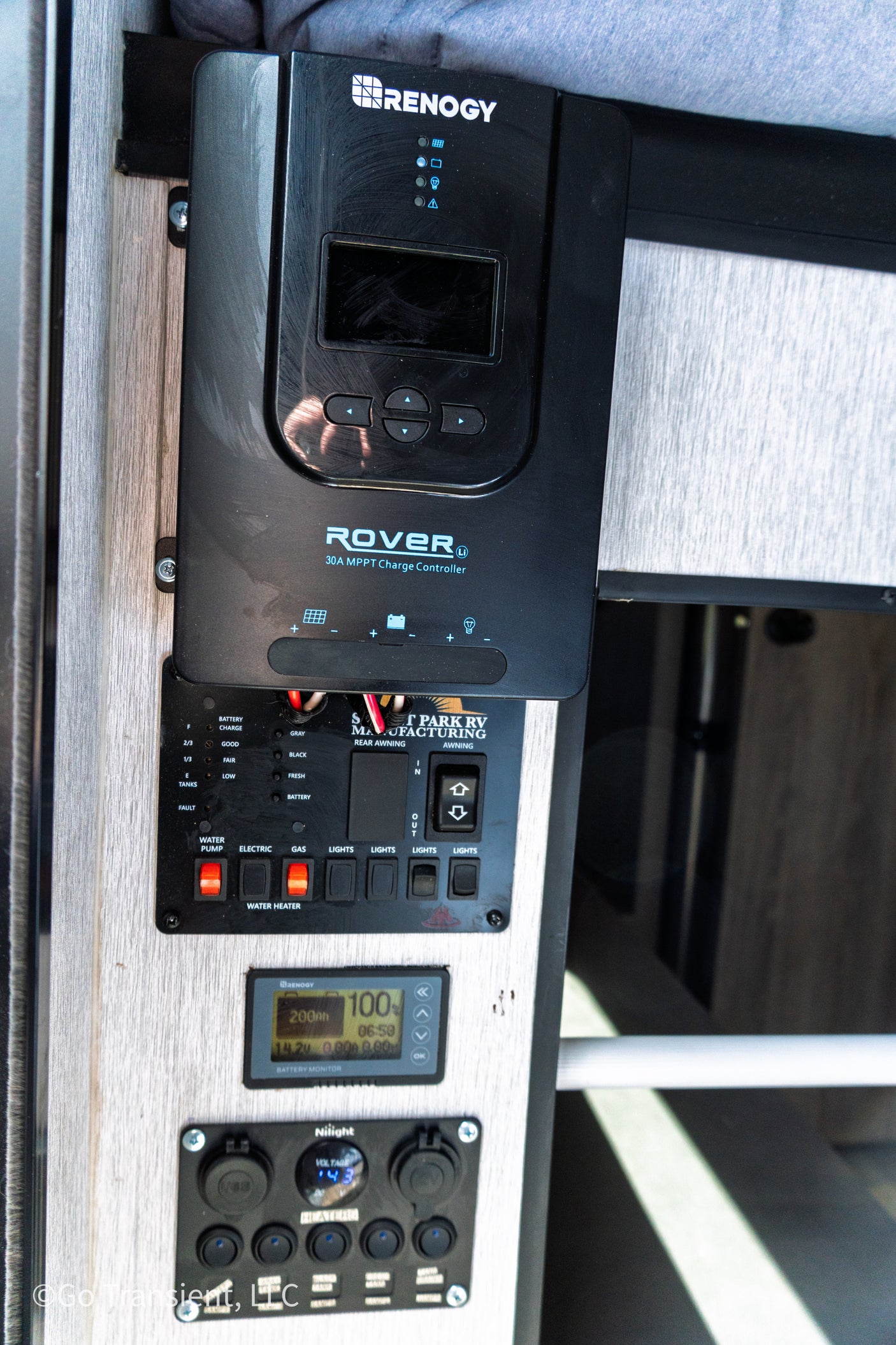 RV rental: Renogy solar charge controller, battery monitor (100%), water/light/awning controls & voltage display.