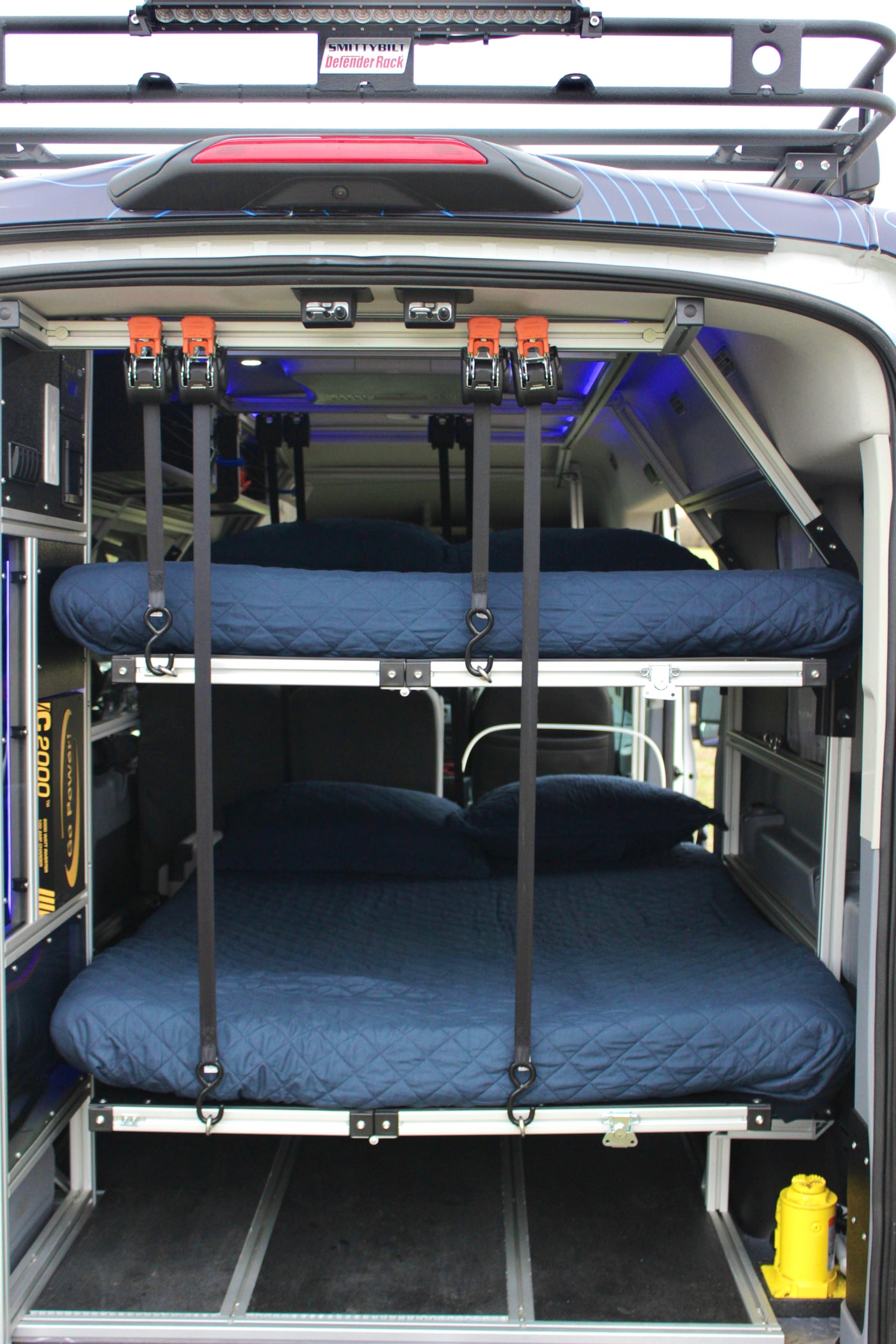 Modular bunk beds inside a custom RV rental, complete with power system & roof rack. Ideal for mobile adventures.