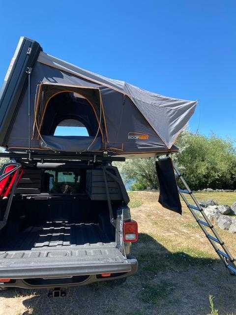 and storage boxes. Ideal for an RV rental for off-road camping.|RV rental alternative: A Roofnest rooftop tent with ladder on a Jeep Gladiator truck