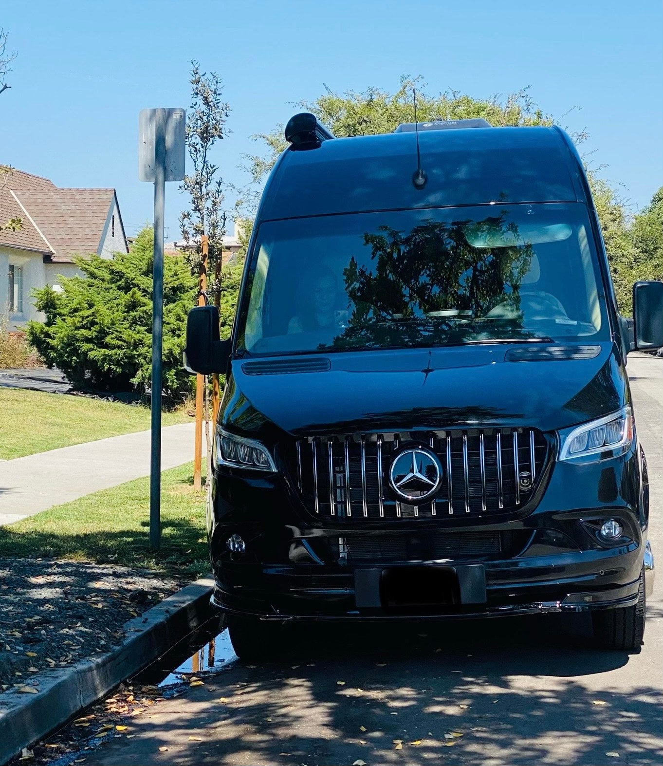 parked on a sunny street.|A black Mercedes Sprinter RV rental parked at a scenic mountain rest stop — photo 2