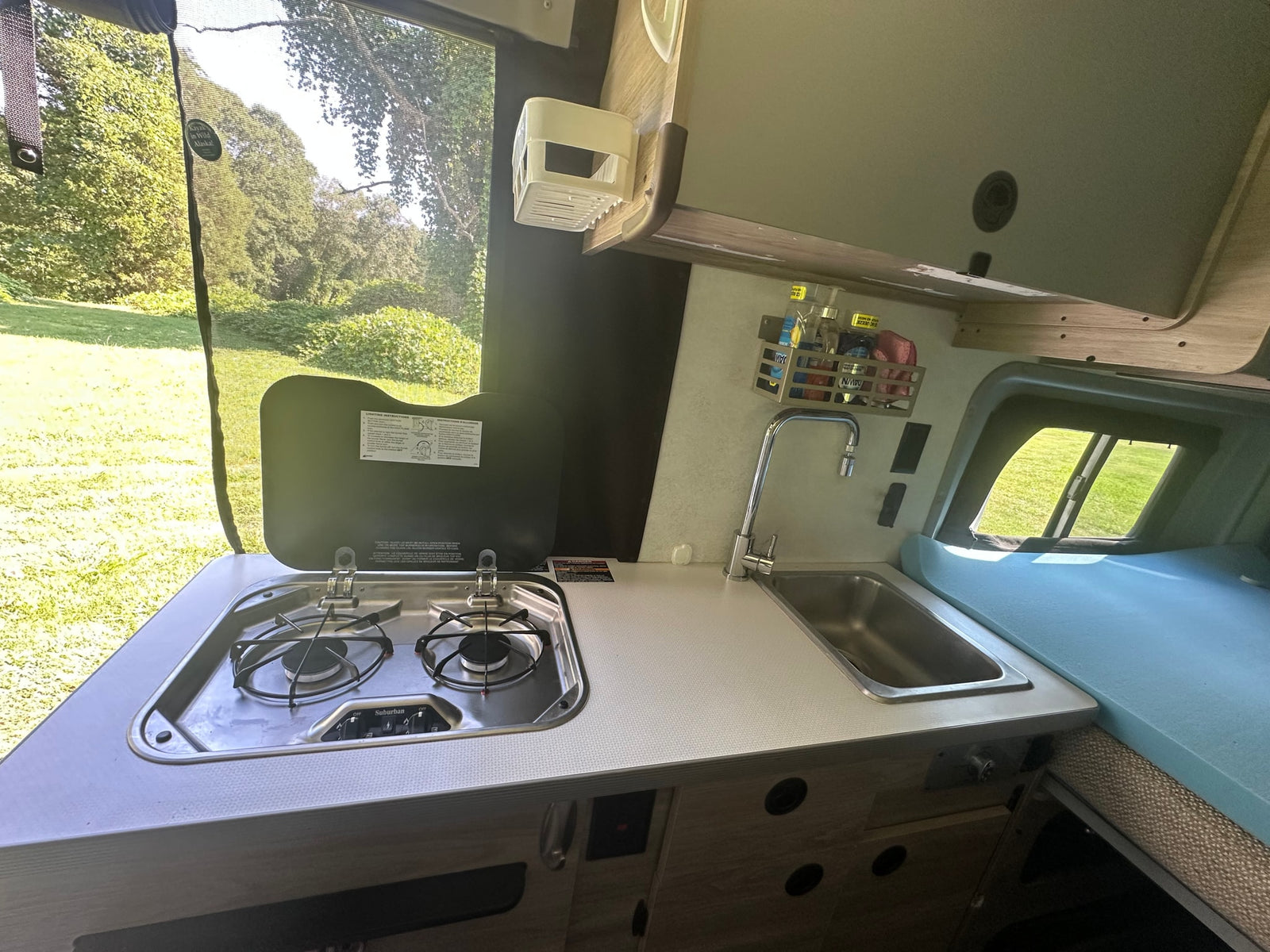parked on sunny green grass.|Experience comfort on the go with this RV rental's compact wet bath